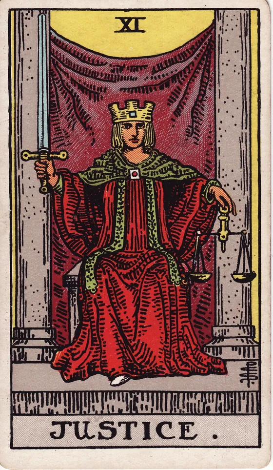Tarotkarte Die Gerechtigkeit: Eine Frau sitzt zwischen zwei Säulen. In der rechten Hand hält sie ein aufgerichtetes Schwert, in der linken eine Waage. Ihr Blick ist offen und gerade.