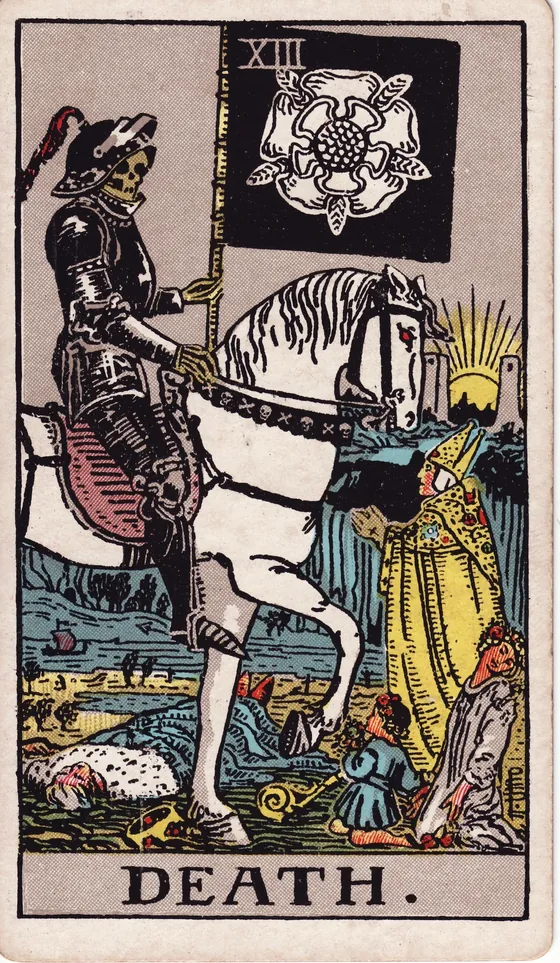 Tarotkarte Der Tod: Ein Skelett in schwarzer Rüstung reitet auf einem weißen Pferd und trägt eine Fahne mit einer weißen Rose. Am Horizont geht zwischen zwei Türmen die Sonne auf.